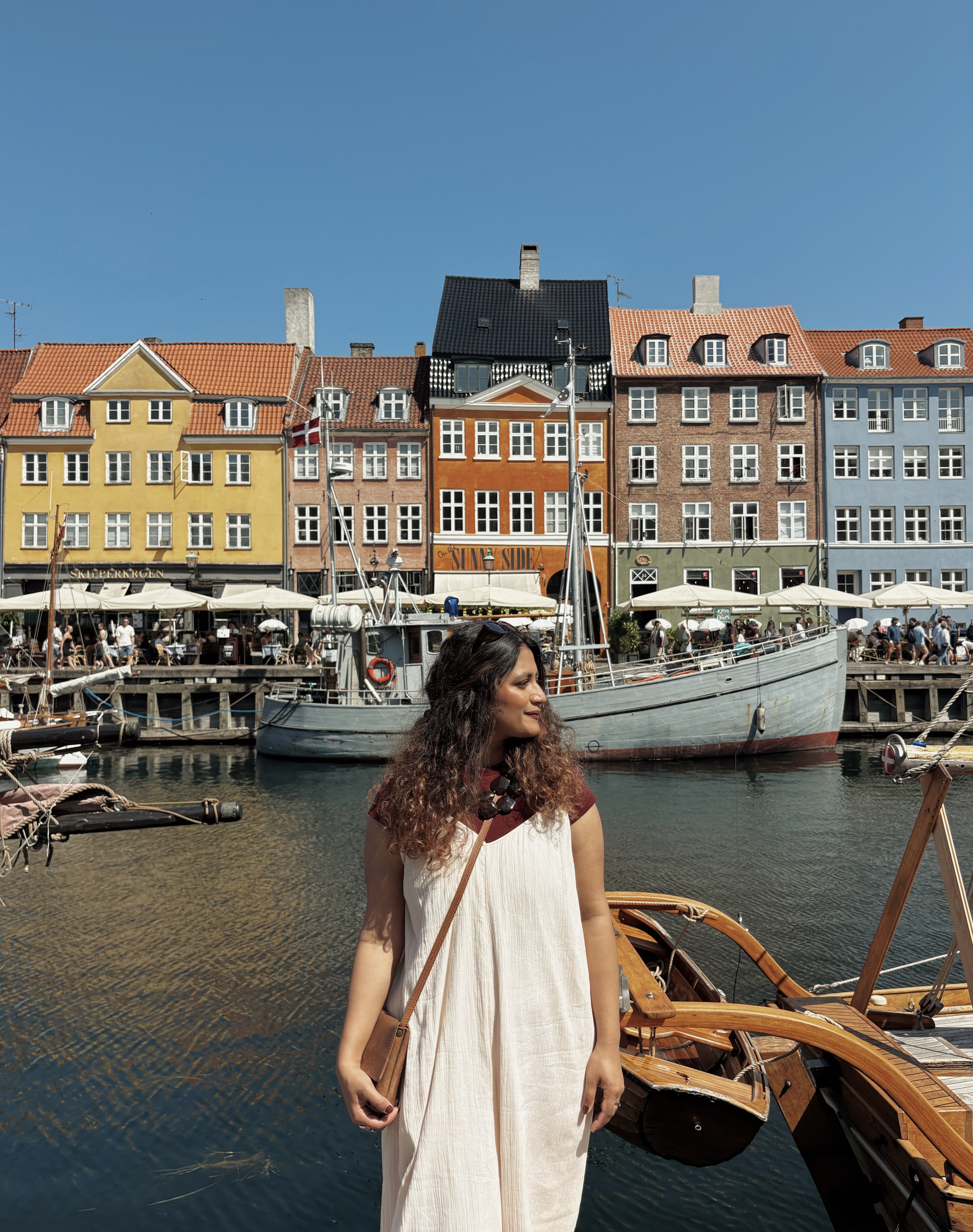 Amna standing in front of the colorful buildings of Copenhagen